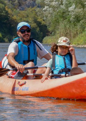 A man with a kid kayaking in river Nestos