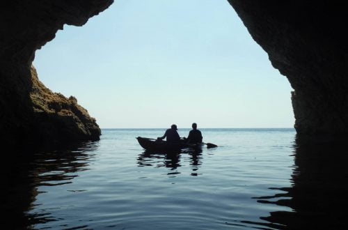 two people kayaking in a sea cave