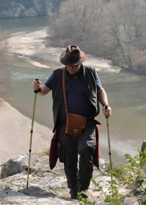 A man hiking with the river in the background
